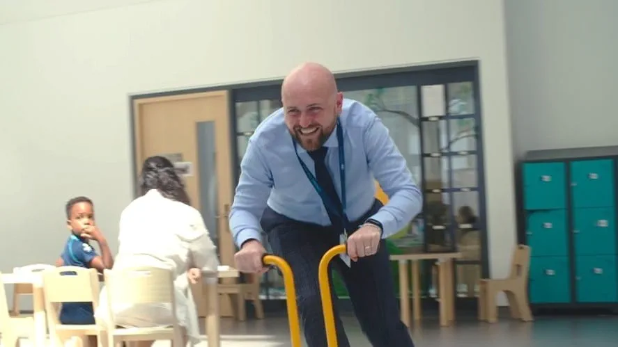 A teacher playing with young children in a classroom